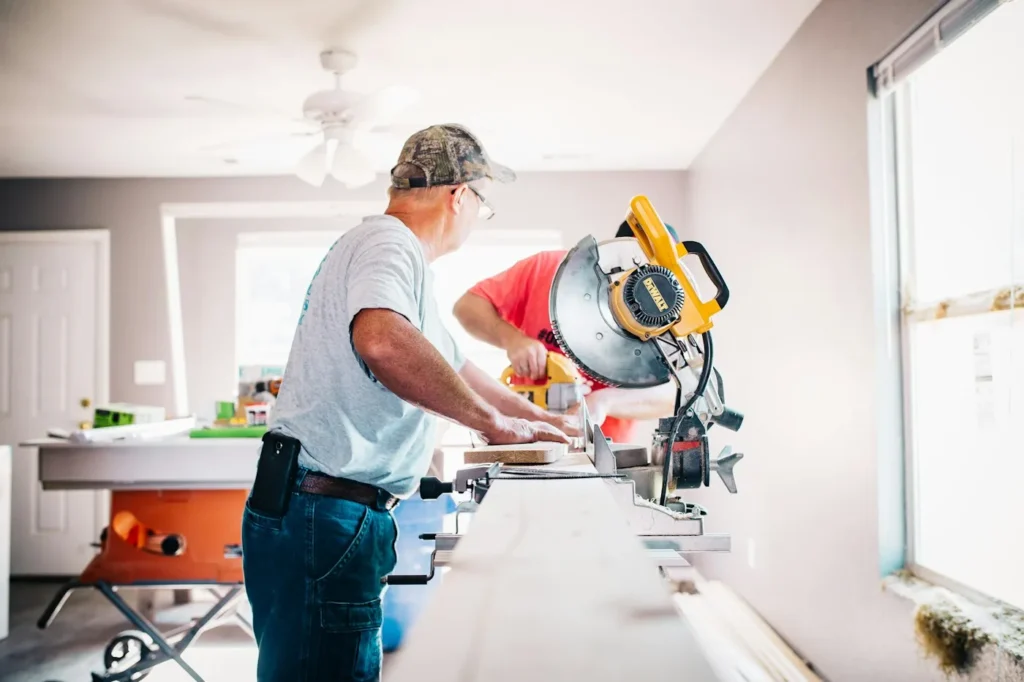 Carpenter cutting timber with a mitre saw